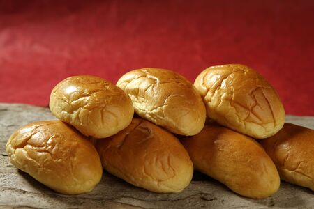 Brioche little bread stacked in two rows over red background