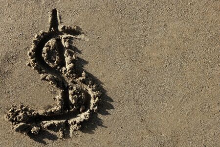 American currency simbol, dollar sign written on the beach sandの写真素材