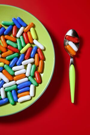 Candy colorful sweets on a green dish over red background