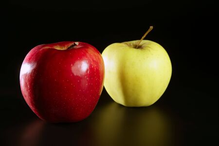 Apple fruit, pair of red and yellow fruits over black backgroundの写真素材
