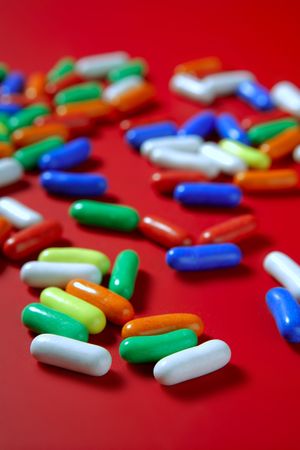 Colorful candy spread over red background, selective focusの写真素材