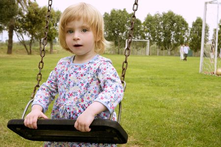 Beautiful toddler blond girl playing on the park playgroundの写真素材