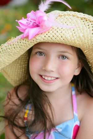 Closeup portrait of beautiful teen little girl with hat in the parkの写真素材