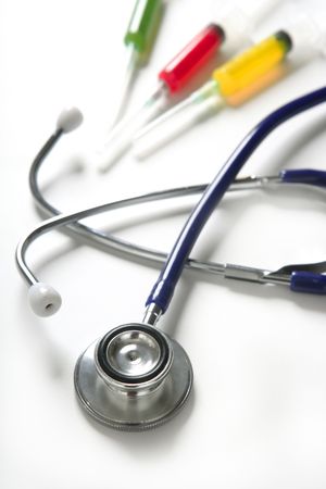 Medical still photo with blue stethoscope and colorful syringe over whiteの写真素材