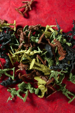 Metaphor of dead plastic toy war soldiers on a red bloody backgroundの写真素材