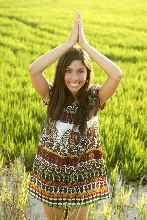 Beautiful brunette indian young woman in the green rice fields meadowの写真素材