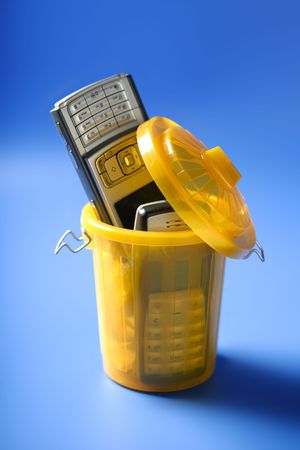 Mobil cell phone on the trash, fed up of communication metaphorの写真素材
