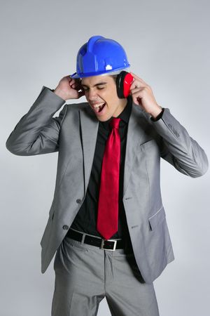Businessman with blue hardhat and safety headphones for noiseの写真素材