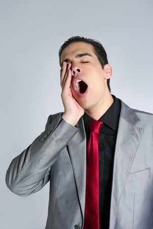 Businessman yawn boring on gray background with suit and red tieの写真素材