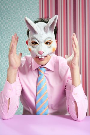 Businessman with funny rabbit mask portrait over wallpaperの写真素材