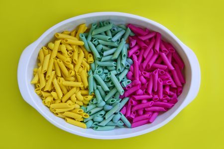Colorful pasta food in three colors, yellow, blue and pinkの写真素材