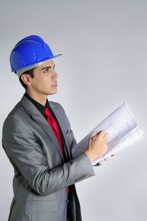Architect engineer with blue hardhat and suit isolated on grayの写真素材