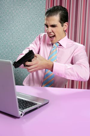 businessman young shooting handgun with computer pink bacgroundの写真素材