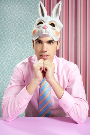 Businessman with funny rabbit mask portrait over wallpaperの写真素材