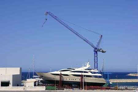 Beached boat with crane on storage area luxury yachtの写真素材