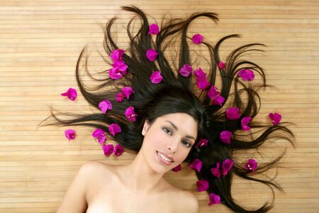 Beautiful indian woman portrait in a beauty spa with bougainvillea flowersの写真素材