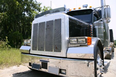 Black huge lorry american truck with stainelss steel in green outdoorの写真素材