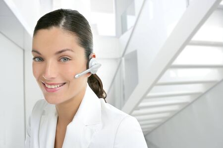 Headset phone business woman dress in white indoor modern office stairの写真素材