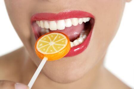 Colorful Lollypop in perfect woman teeth and red lips mouthの写真素材