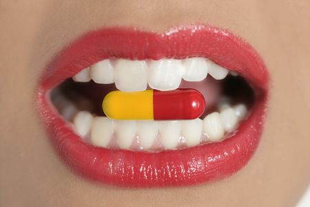 Beauty woman mouth with red lips and medicine pillの写真素材