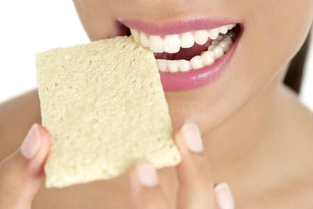 Biscuit in woman teeth and mouth having a healthy snackの写真素材