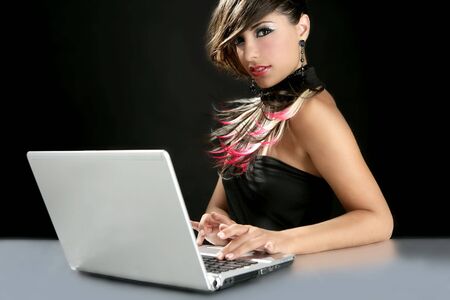 Attractive brunette fashion woman with laptop over blackの写真素材