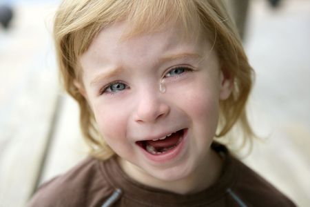 Adorable blond little girl crying closeup portraitの写真素材