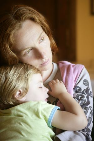 Baby toddler girl sleeping in redhead mother arms tranquil sceneの写真素材