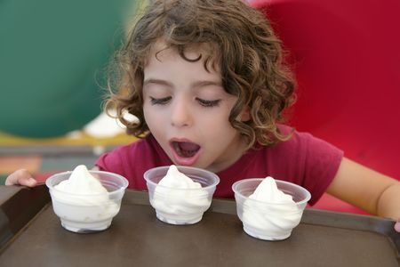 Adorable little girl holding tray with three ice cream over colorful backgroundの写真素材