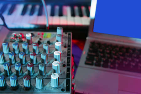 Audio mixer music desk under colorful lights equipment