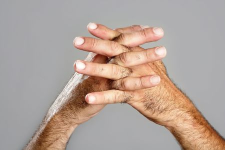 Hairy man hand closeup expression over gray backgroundの写真素材