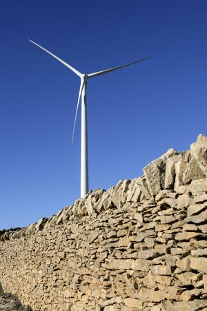 Electric windmills with a masonry rural wall on the front