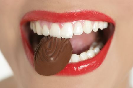 Chocolate sweet in beautiful woman mouth macroの写真素材