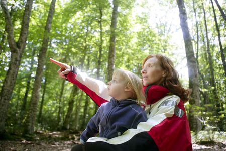 Beautiful blond little daughter with her mother inn the forestの写真素材