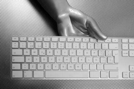 Futuristic silver gray hand and computer keyboardの写真素材