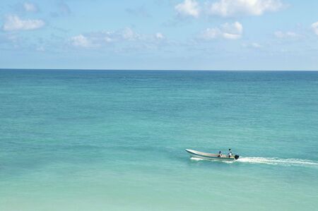 tropical caribbean sea with boat on turquoise waterの写真素材