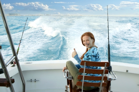 fisherwoman big game on boat chair ok sign happyの写真素材