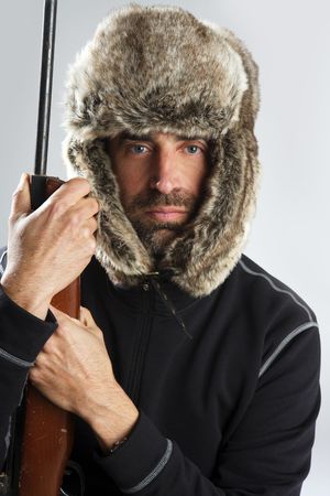 hunter winter fur hat man portrait holding gunの写真素材