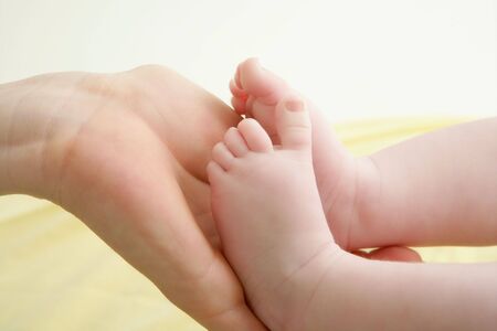 baby feet in mother hands playing together