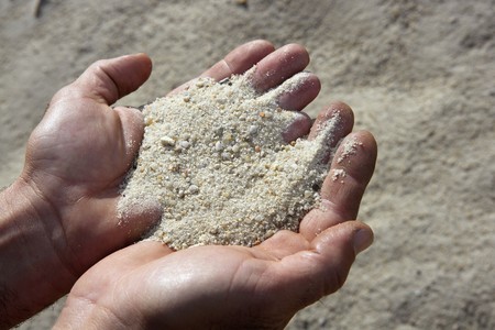 gravel sand in man hands in quarry showing cameraの写真素材