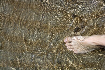 beach tourist feet walking on shore shallow water summer vacation metaphor  