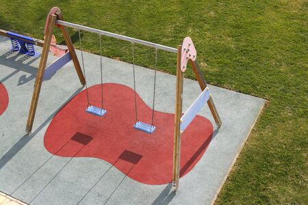 children park swing green grass high view rubber red soilの写真素材
