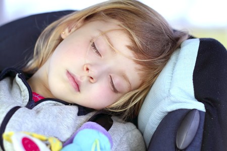 little girl sleeping on children car safety seat belt happy dreamsの写真素材