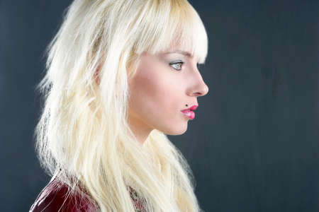 blond young girl profile portrait over gray backgroundの写真素材