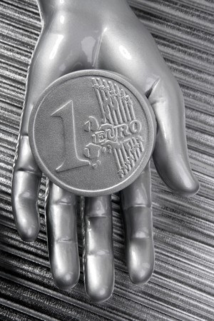 euro silver coin of futuristic metallic silver hand money metaphorの写真素材
