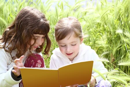 two little sister girls reading book spikes gardenの写真素材
