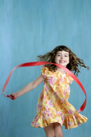 action little girl red ribbon tape dancing over green motionの写真素材