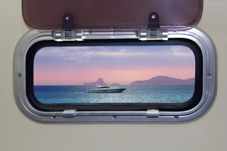 Boat porthole sunset view red blue ocean sea magic lightの写真素材