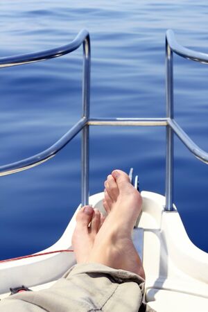 boat bow man feet blue sea view sailing ocean relaxed calm saltwaterの写真素材