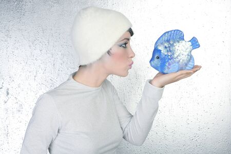 woman profile holding fish kissing expression silver backgroundの写真素材